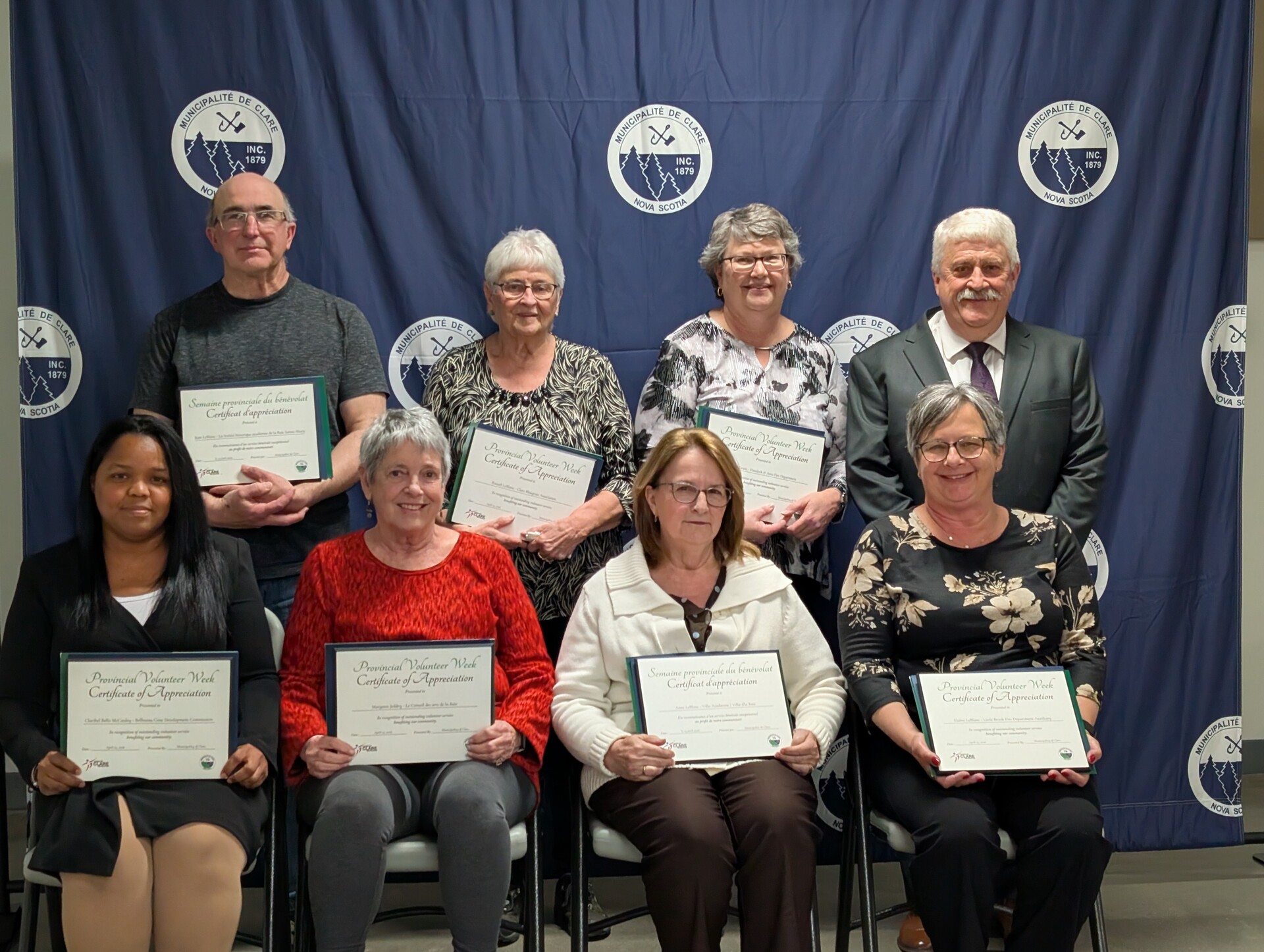 De gauche à droite:  Rangée arrière: Jean LeBlanc, Grace LeBlanc , Christine Lewis, Sous-préfet Eric Pothier. Rangée avant: Claribel Bello McCauley, Margaret Jeddry, Anne LeBlanc, Elaine LeBlanc.
