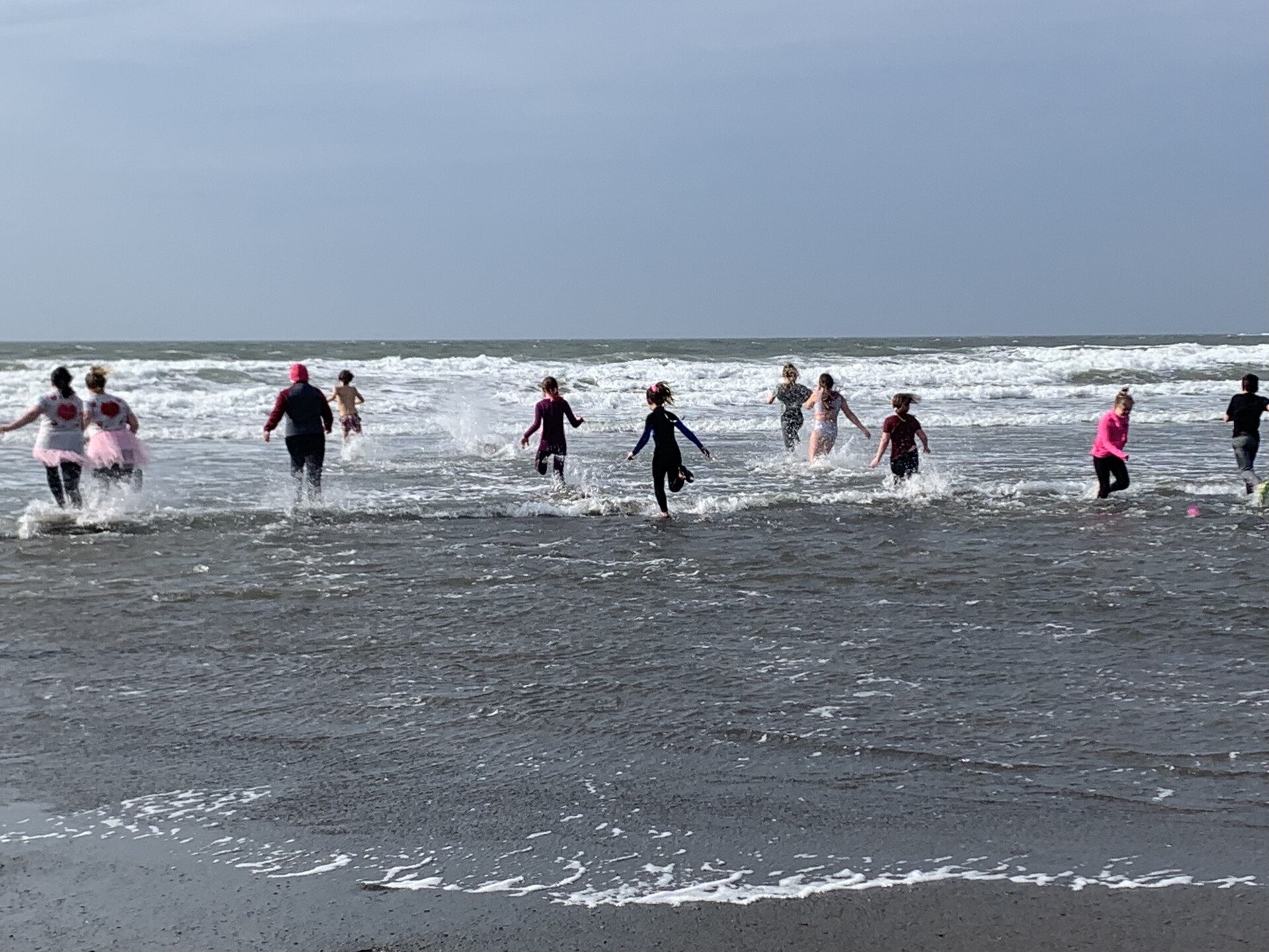 People running into the ocean