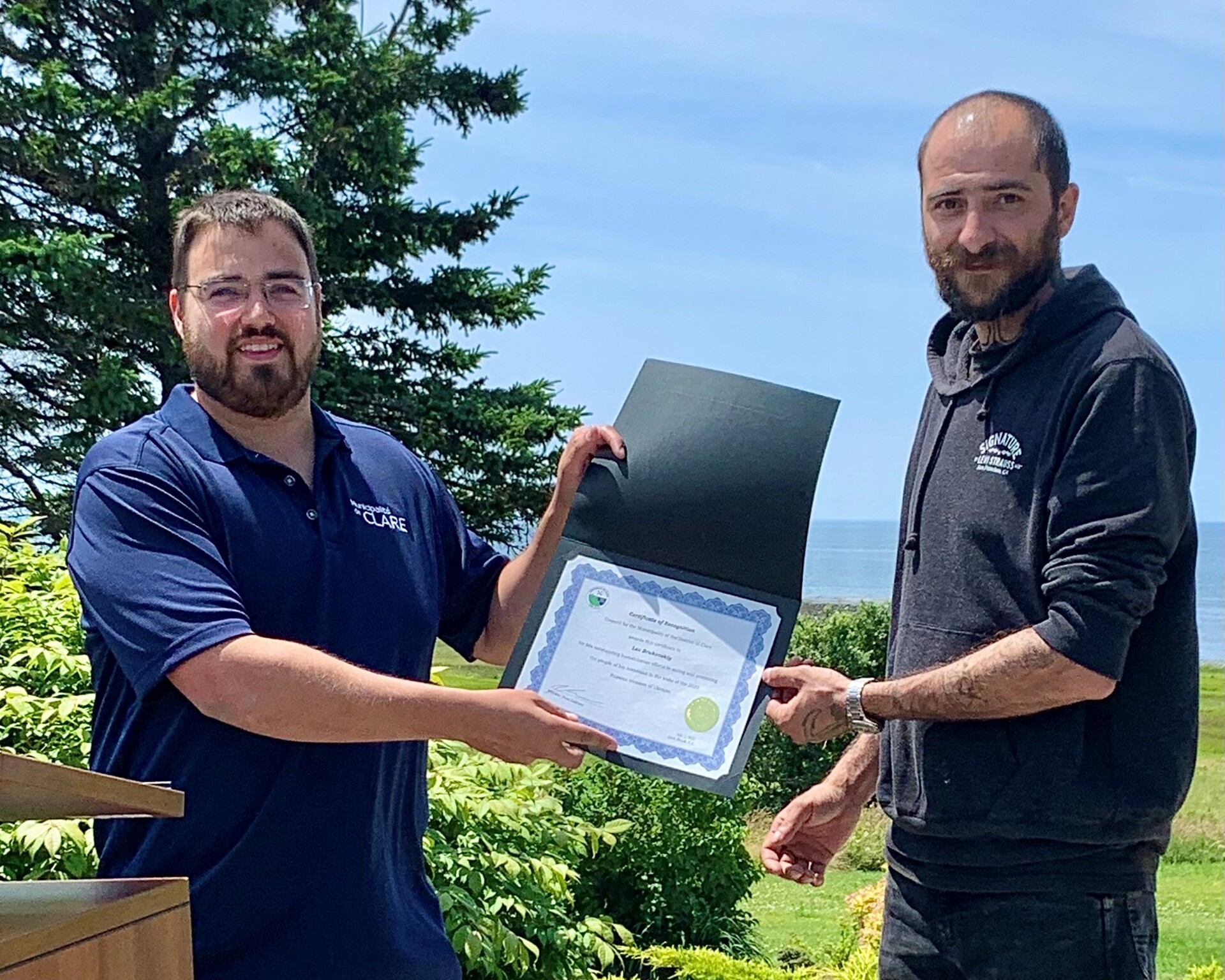 Two people presenting a certificate